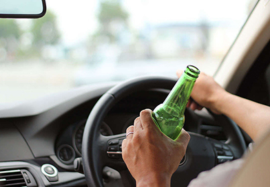 green-beer-bottle-held-while-driving